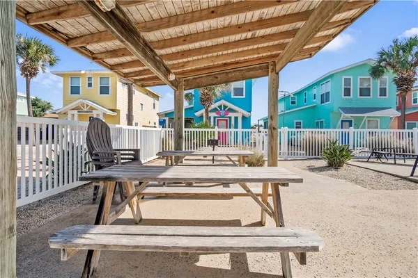 a view of a patio with a table and chairs and wooden fence