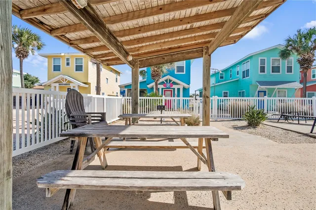 a view of a patio with a table and chairs and wooden fence