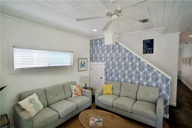 a living room with furniture and a ceiling fan