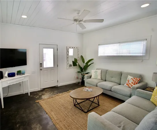 a living room with furniture a flat screen tv and a window