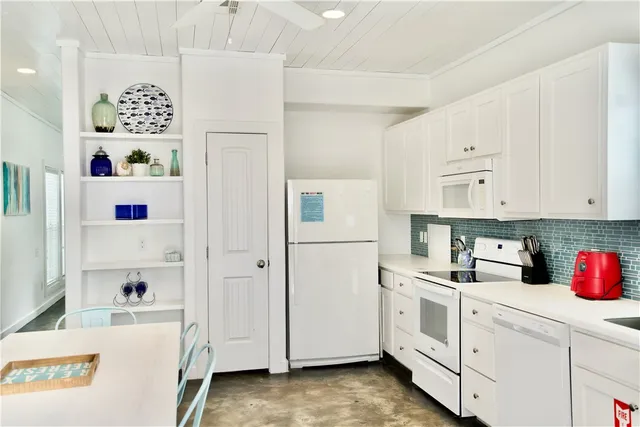 a kitchen with refrigerator and white cabinets