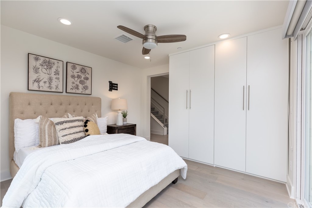 5505 River Avenue Newport Beach, CA 92663 - Photo 17 of 40 a bedroom with a large bed and a ceiling fan