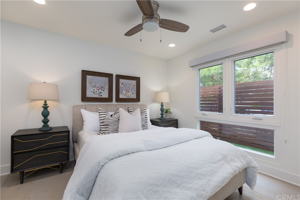 5505 River Avenue Newport Beach, CA 92663 - Photo 19 of 40 a bedroom with a bed and a chandelier