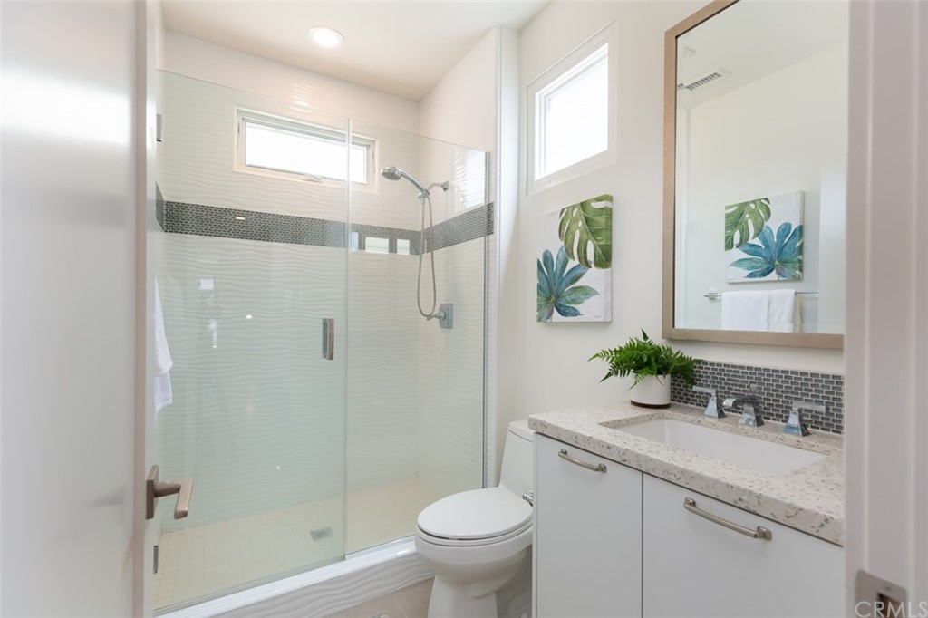 5505 River Avenue Newport Beach, CA 92663 - Photo 21 of 40 a bathroom with a granite countertop sink a toilet and shower