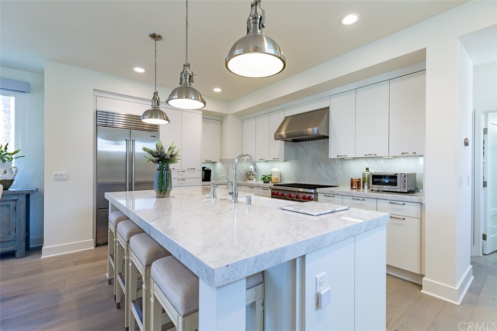 5505 River Avenue Newport Beach, CA 92663 - Photo 6 of 40 a kitchen that has a lot of cabinets in it and wooden floors