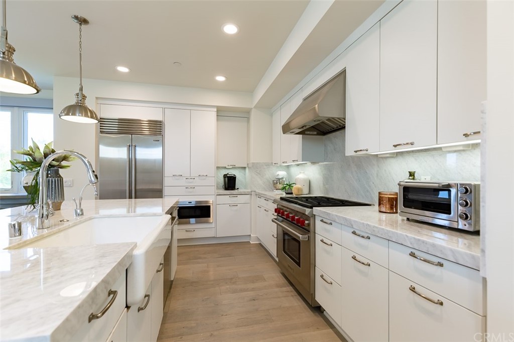 5505 River Avenue Newport Beach, CA 92663 - Photo 7 of 40 a kitchen with stainless steel appliances granite countertop a stove sink and cabinets