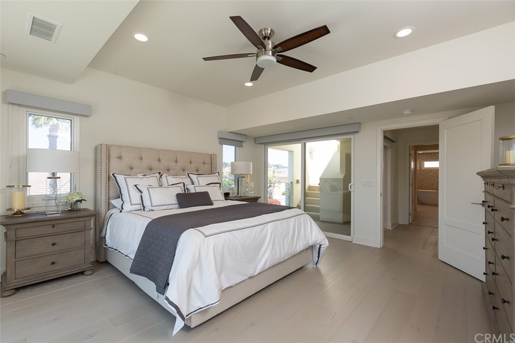 5505 River Avenue Newport Beach, CA 92663 - Photo 9 of 40 a bedroom with a bed and a chandelier