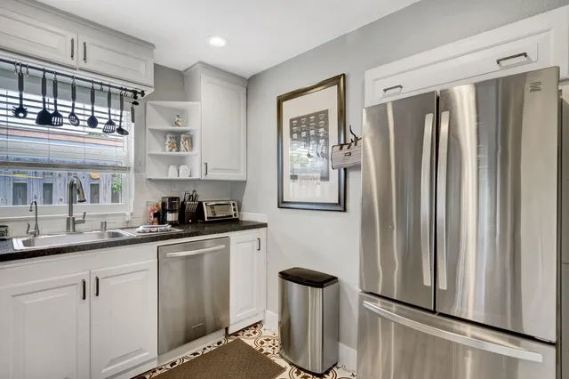a kitchen with stainless steel appliances granite countertop a refrigerator and a sink