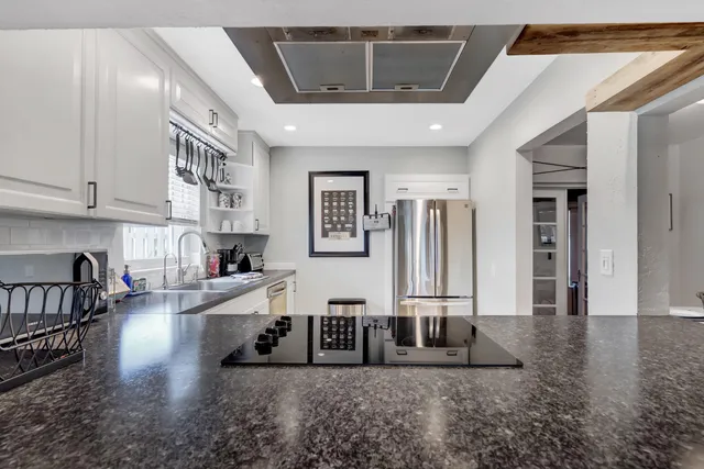 a kitchen with stainless steel appliances granite countertop a refrigerator and stove