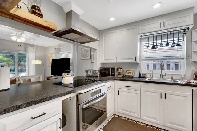 a kitchen with granite countertop a sink and white cabinets