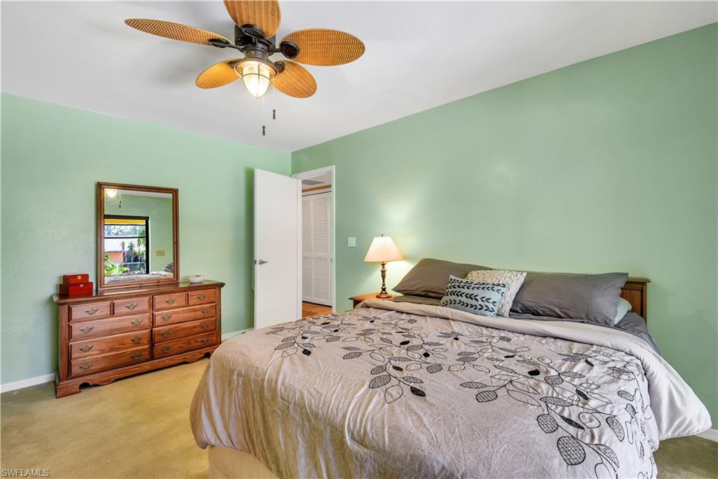 8444 Lemon Road Fort Myers, FL 33967 - Photo 18 of 30 a bedroom with a bed and dresser with mirror