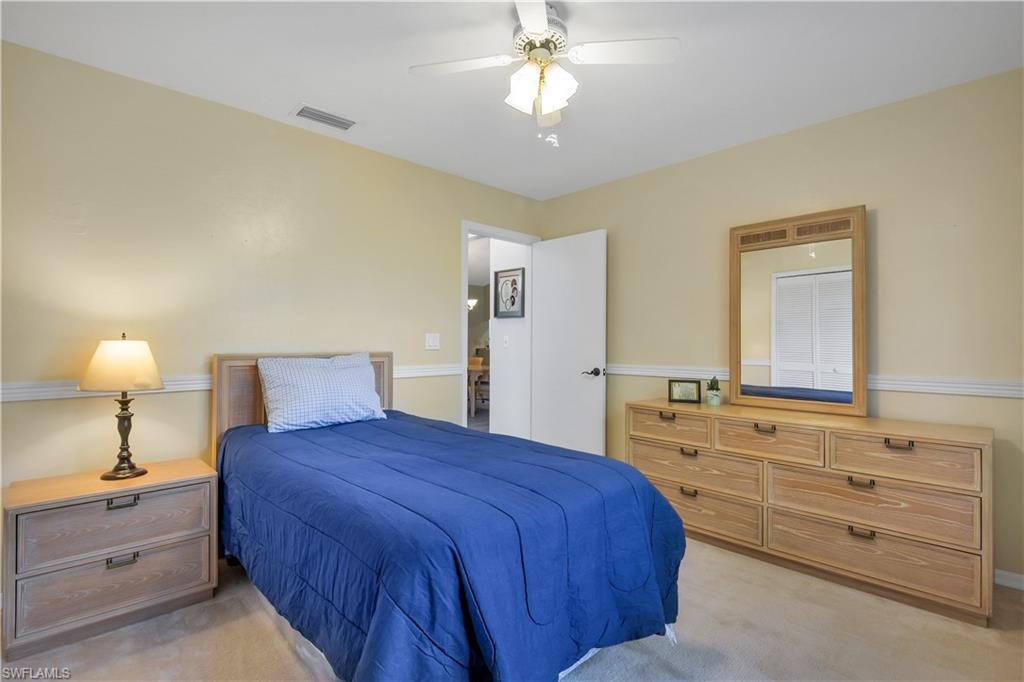 8444 Lemon Road Fort Myers, FL 33967 - Photo 22 of 30 a spacious bedroom with a bed and a chandelier