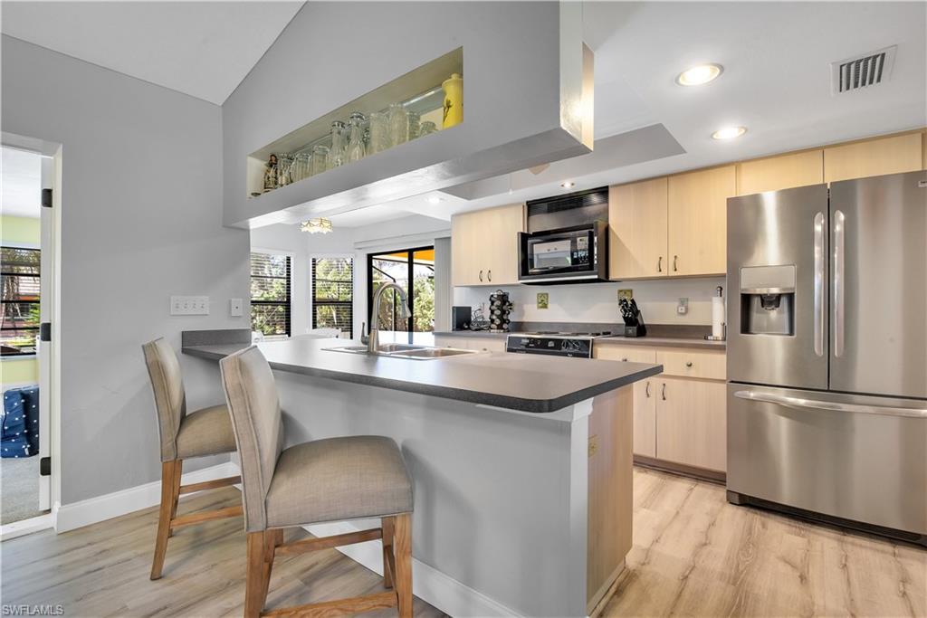 8444 Lemon Road Fort Myers, FL 33967 - Photo 9 of 30 a kitchen with stainless steel appliances granite countertop a sink a stove a refrigerator and island with wooden floor