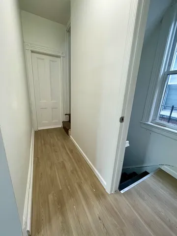 an empty room with wooden floor and a window