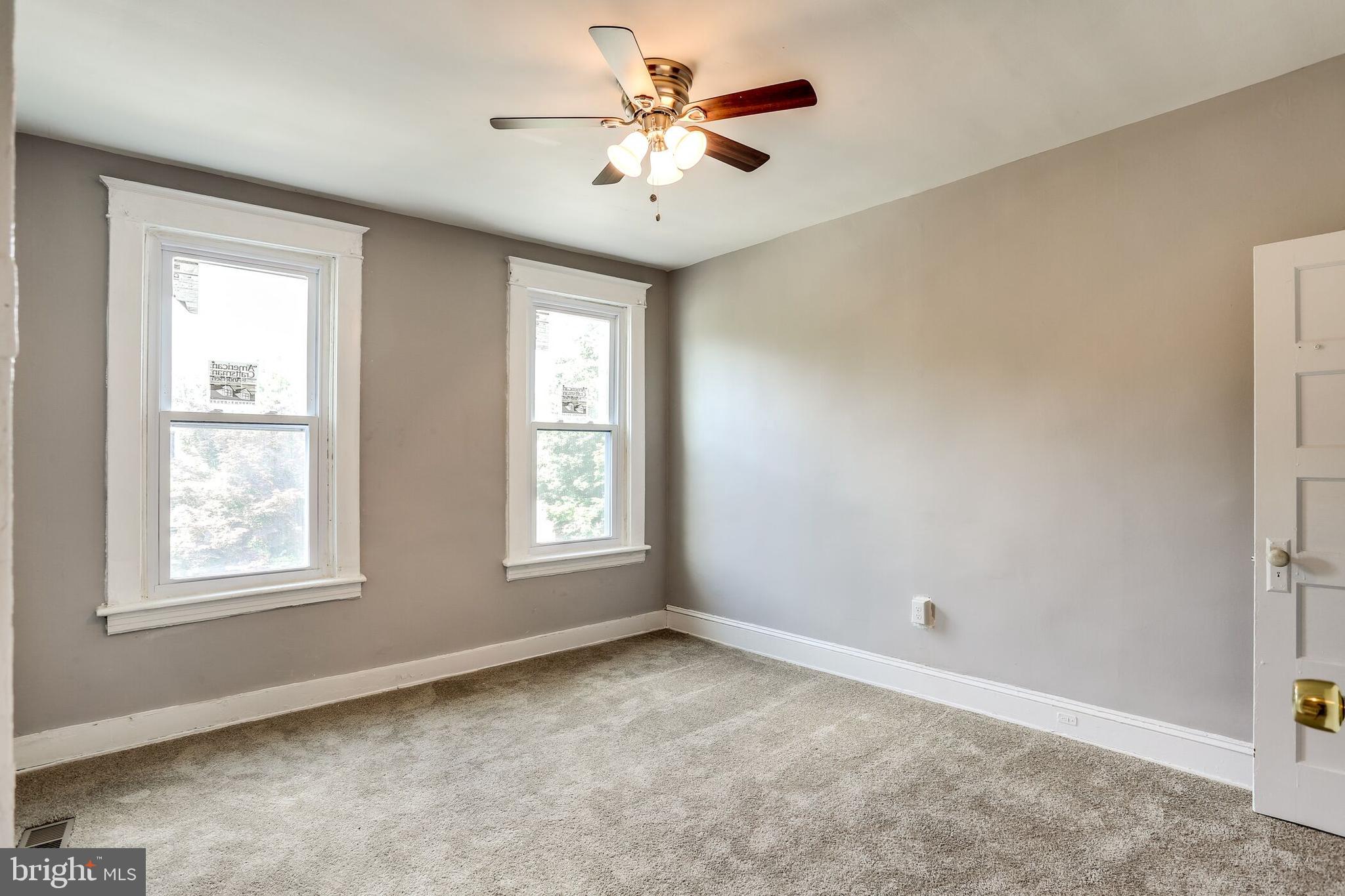 713 Springfield Avenue Baltimore, MD 21212 - Photo 14 of 28 an empty room with windows and chandelier fan