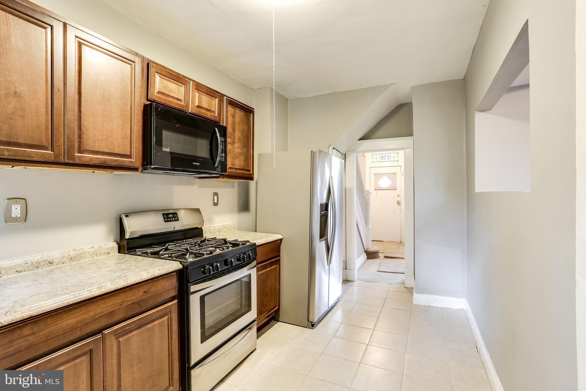 713 Springfield Avenue Baltimore, MD 21212 - Photo 9 of 28 a kitchen with stainless steel appliances a stove a microwave and cabinets