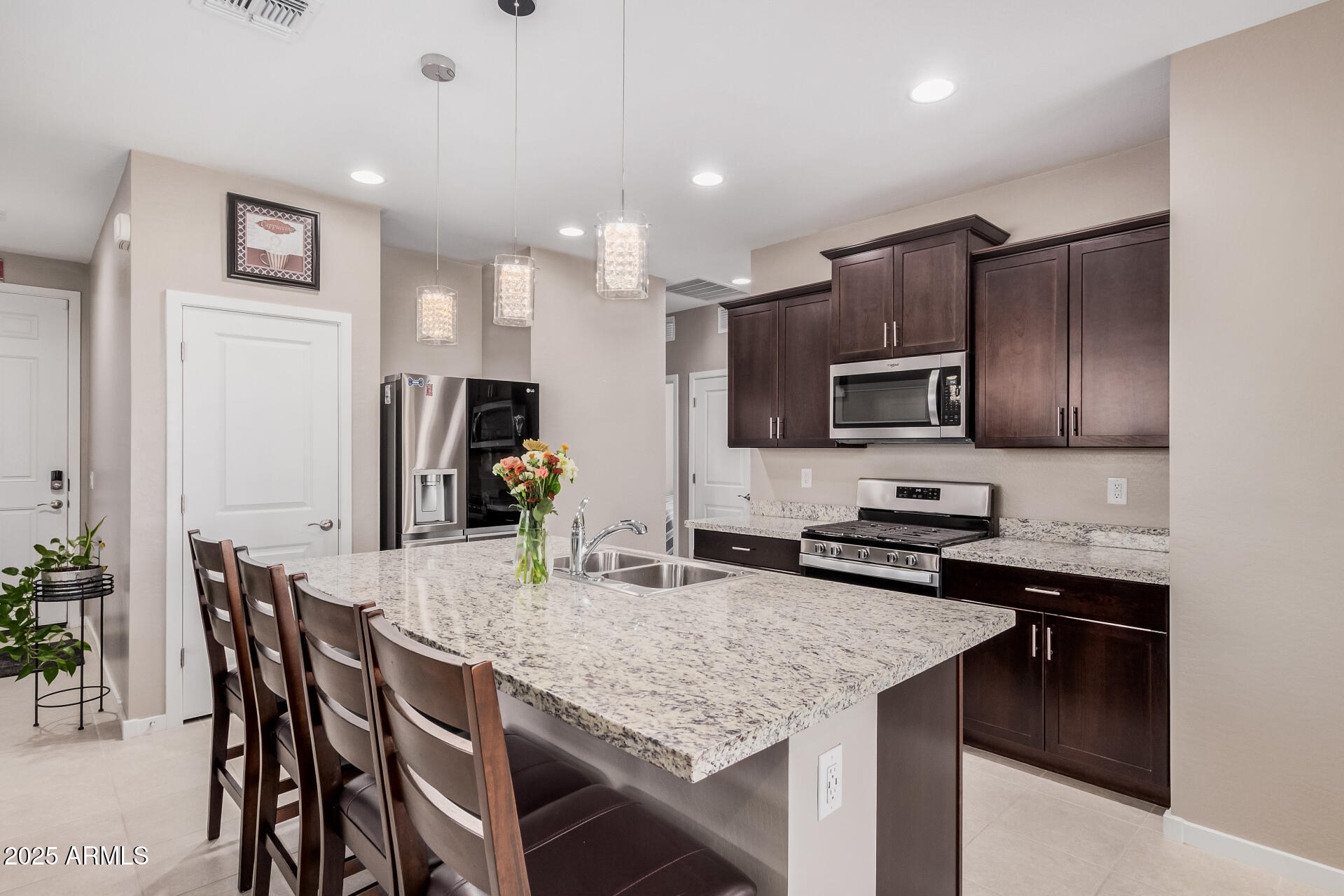 10736 West Chipman Road Tolleson, AZ 85353 - Photo 1 of 27 a kitchen with granite countertop kitchen island cabinets stainless steel appliances and a counter space