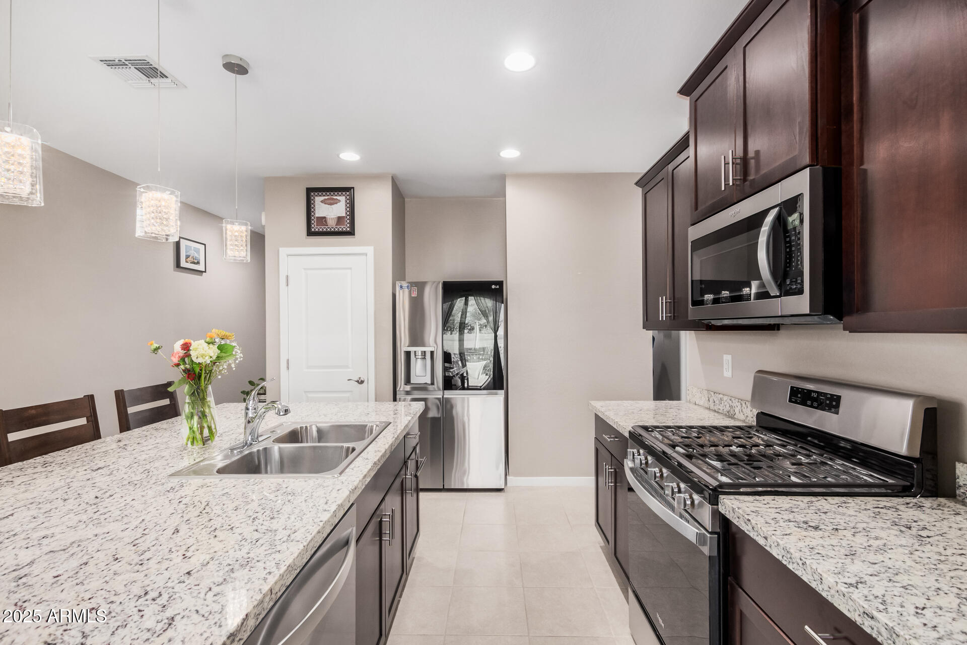 10736 West Chipman Road Tolleson, AZ 85353 - Photo 10 of 27 a kitchen with granite countertop stainless steel appliances cabinets a sink and a counter top space
