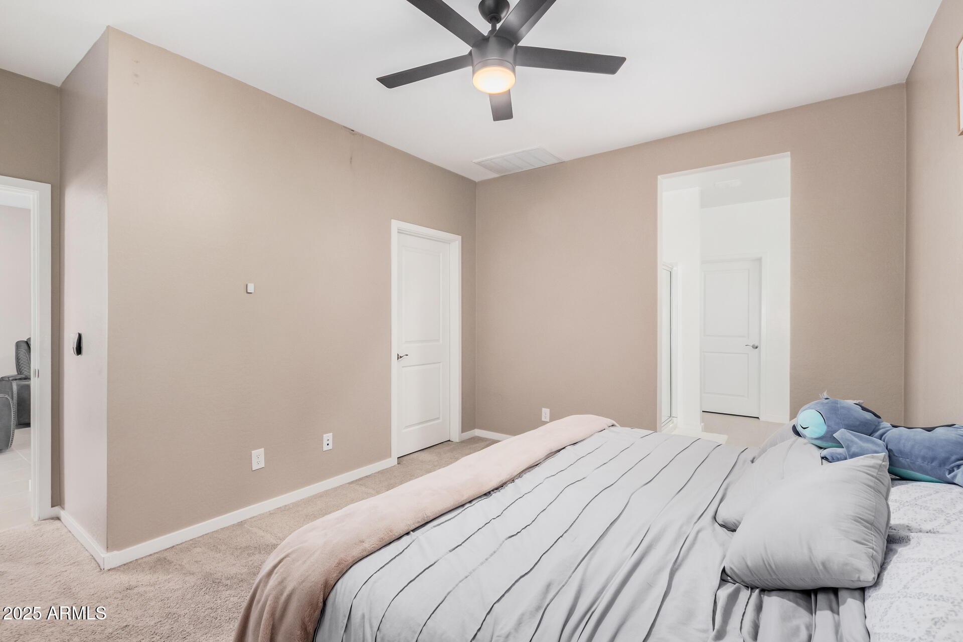 10736 West Chipman Road Tolleson, AZ 85353 - Photo 11 of 27 a bedroom with a large bed and a chandelier