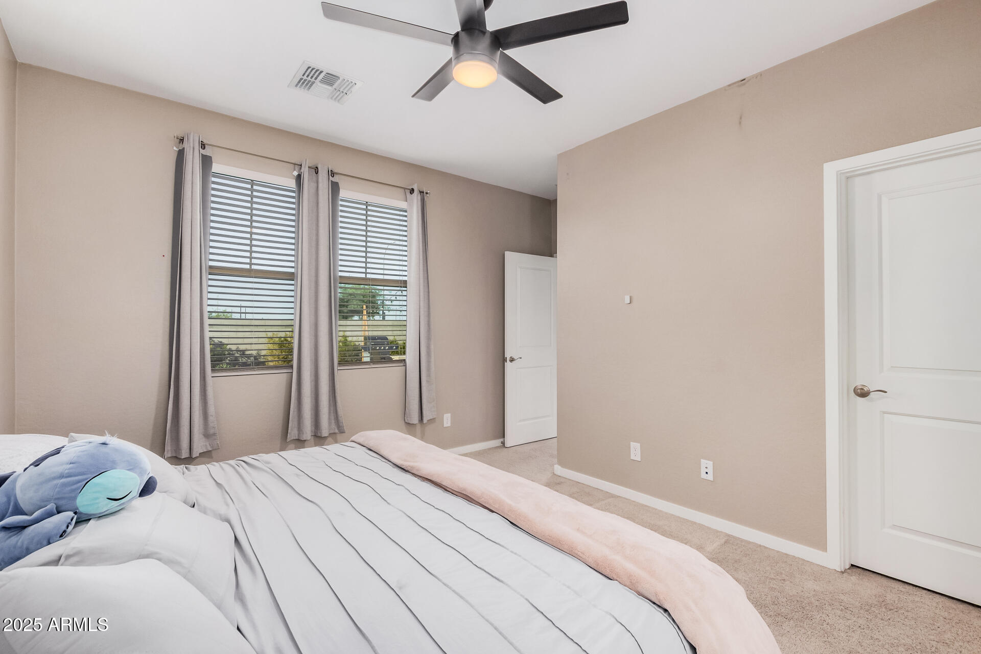 10736 West Chipman Road Tolleson, AZ 85353 - Photo 14 of 27 a bedroom with a bed and a window