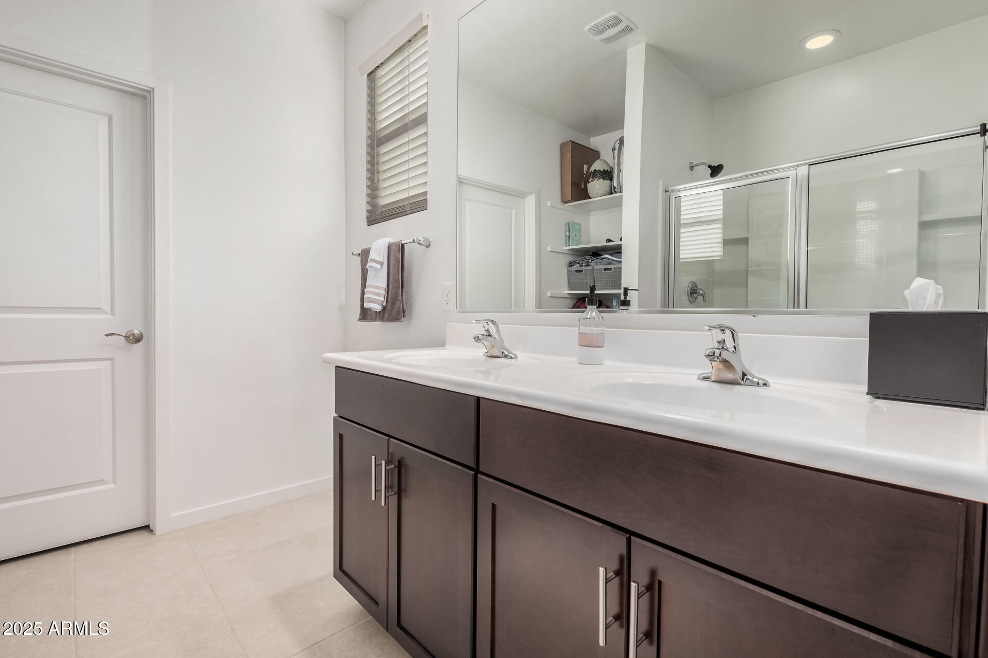 10736 West Chipman Road Tolleson, AZ 85353 - Photo 16 of 27 a bathroom with a double vanity sink a mirror and shower