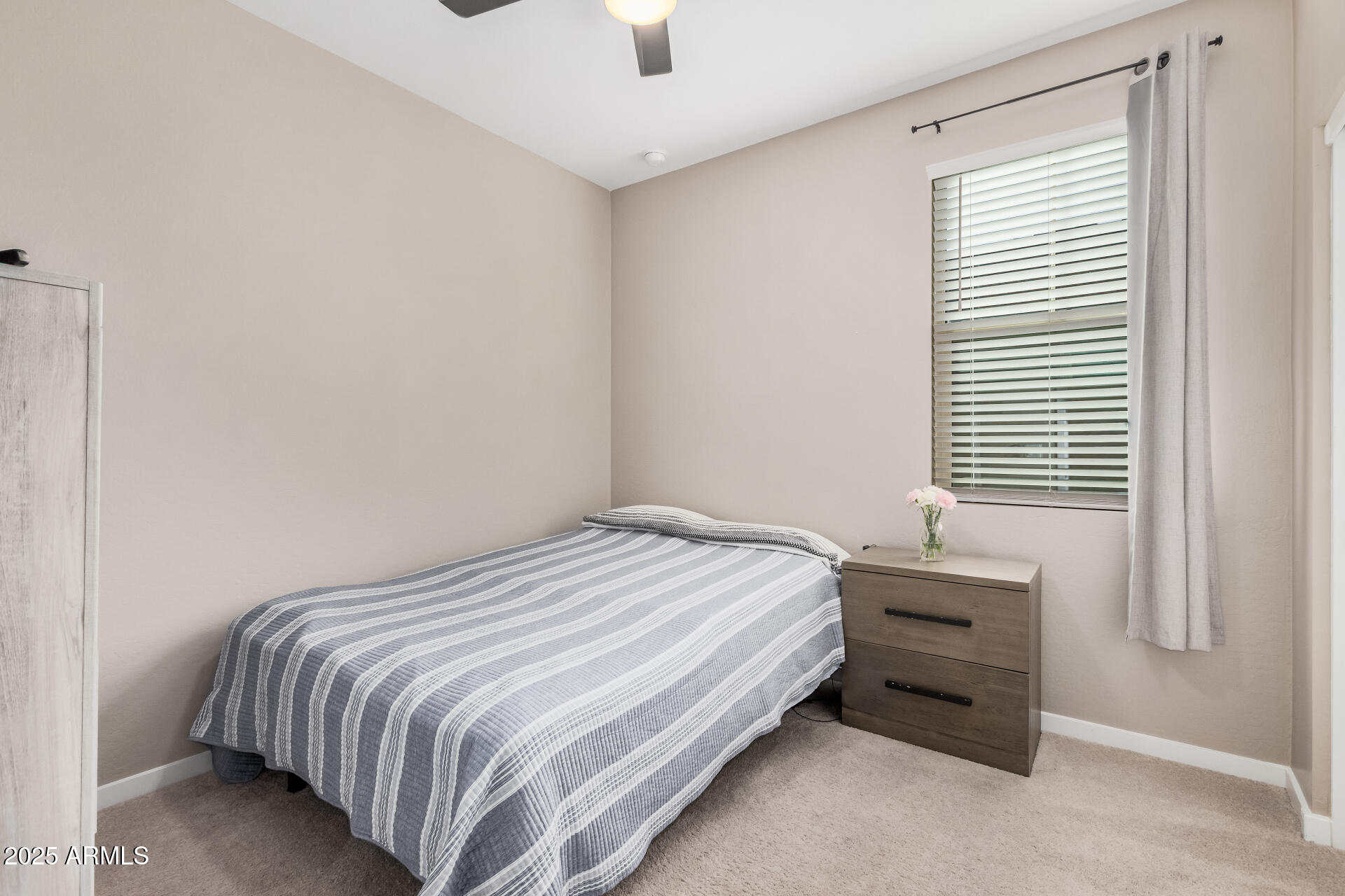 10736 West Chipman Road Tolleson, AZ 85353 - Photo 18 of 27 a bedroom with a bed and a window