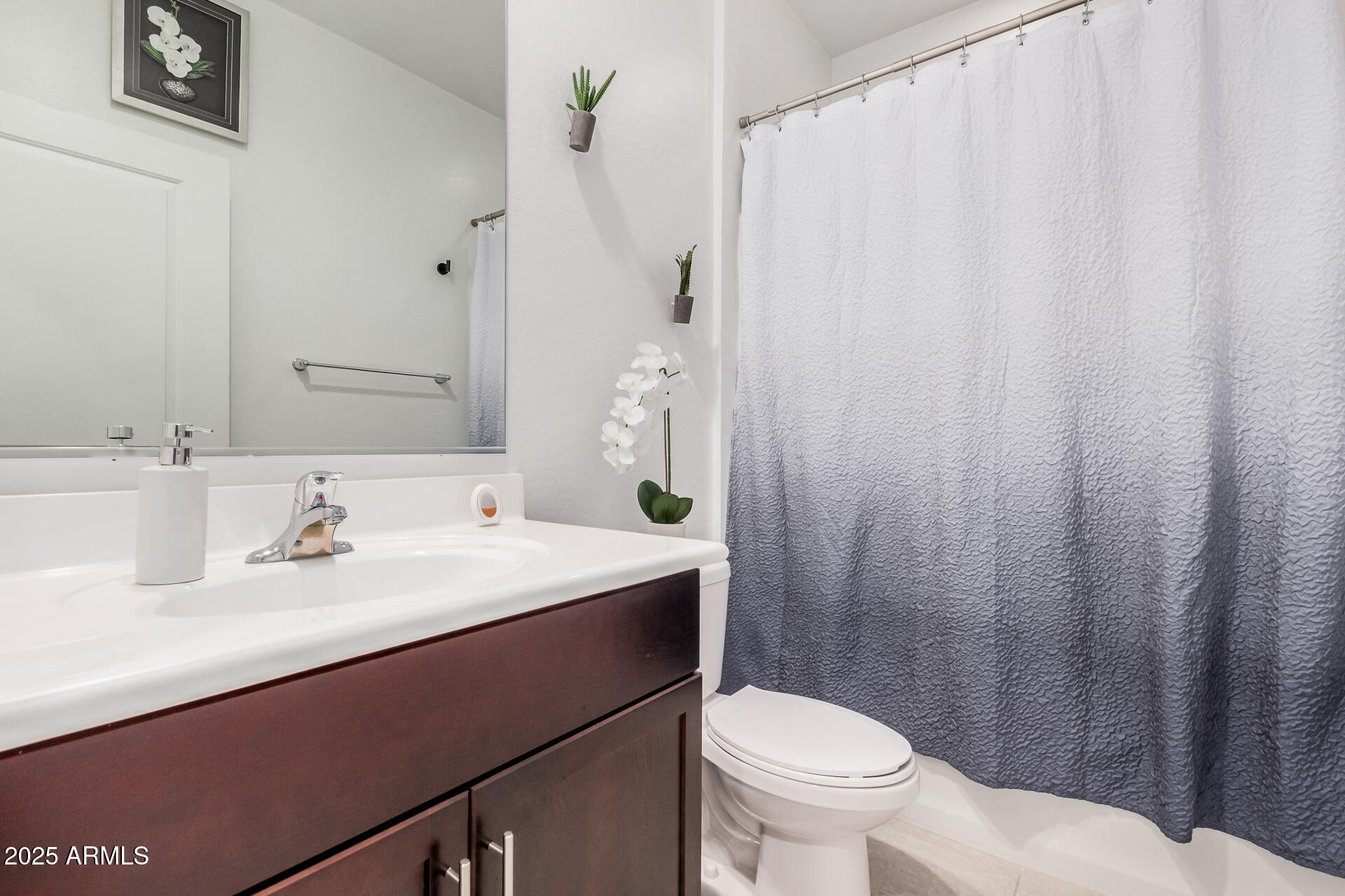 10736 West Chipman Road Tolleson, AZ 85353 - Photo 22 of 27 a bathroom with a sink a toilet and a mirror