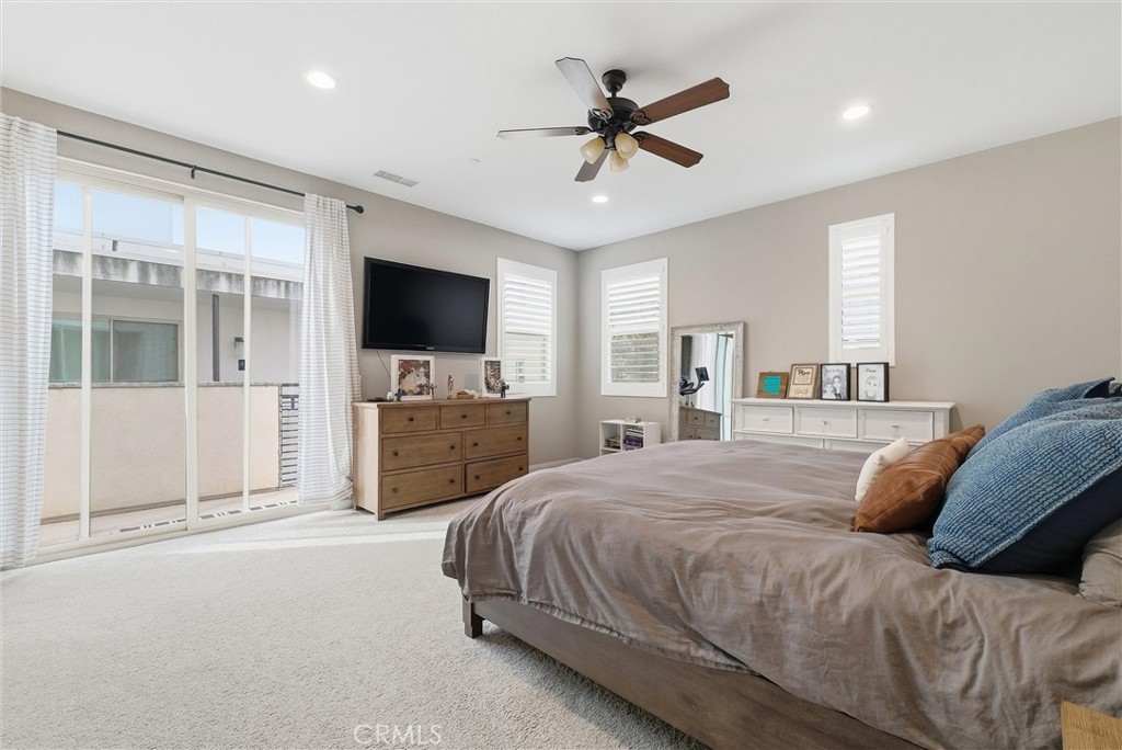 155 Spectacle Irvine, CA 92618 - Photo 27 of 40 a spacious bedroom with a bed a flat screen tv and a chandelier