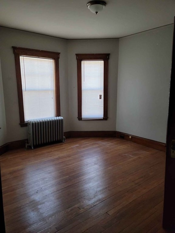57 Austin Street, Unit 2 Boston, MA 02136 - Photo 16 of 17 an empty room with wooden floor and windows