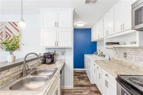 a kitchen with a sink stove and cabinets
