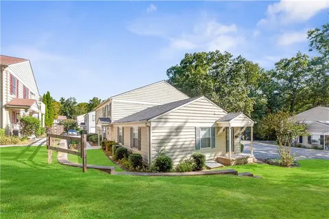 a front view of a house with a yard and green space