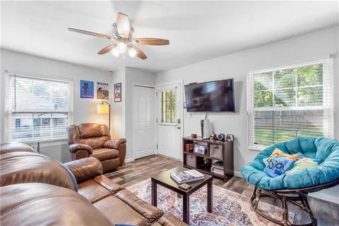 a living room with furniture a flat screen tv and a large window