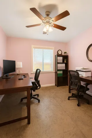 a view of a workspace with furniture and a window