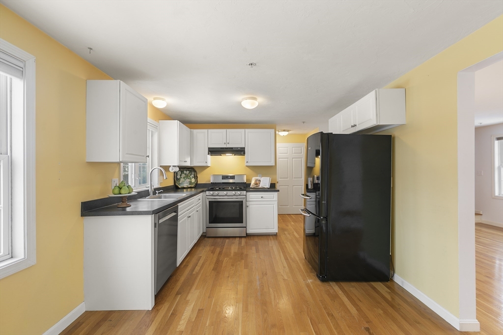985 Trapelo Road, Unit 11 Waltham, MA 02452 - Photo 3 of 23 a kitchen with a refrigerator a stove top oven and wooden floor