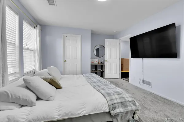 a bedroom with a bed and a flat screen tv
