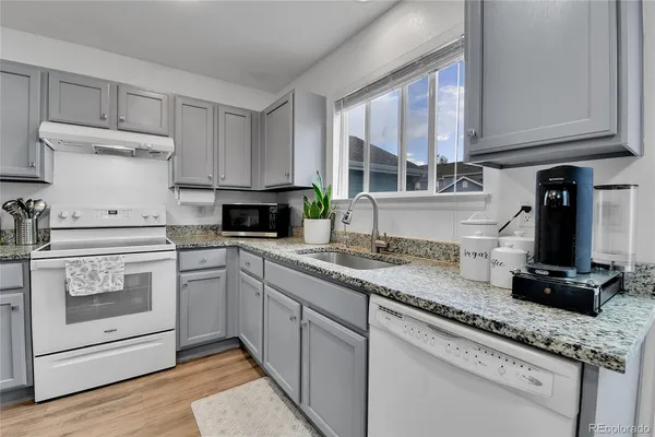 a kitchen with granite countertop a sink stainless steel appliances and cabinets