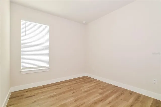 an empty room with wooden floor and a window