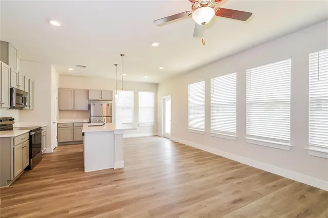 a view of kitchen with stainless steel appliances refrigerator stove microwave and cabinets