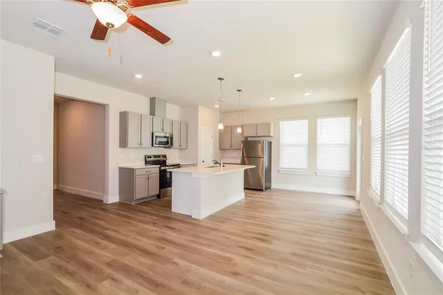 a view of kitchen with kitchen island wooden floors appliances and center island