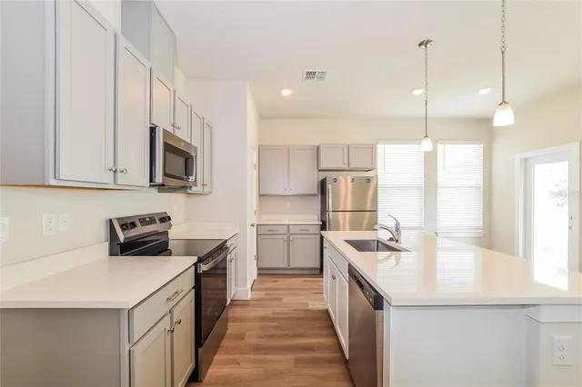 a kitchen with a sink stove top oven and refrigerator
