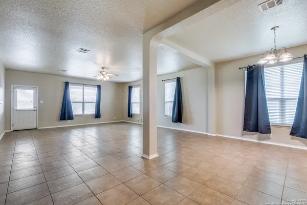 a view of an empty room with window and cabinet