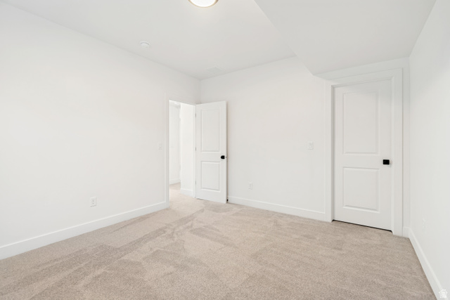 1351 Maple Circle Santaquin, UT 84655 - Photo 38 of 42 Carpeted room featuring white walls, white trim, two white panel doors with black hardware, and a ceiling light fixture