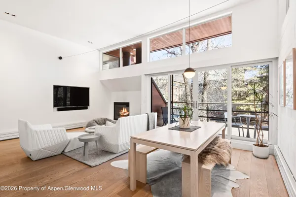 a living room with furniture a flat screen tv and a floor to ceiling window
