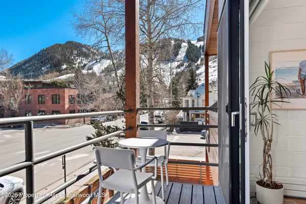 a view of a balcony with two chairs and a potted plant