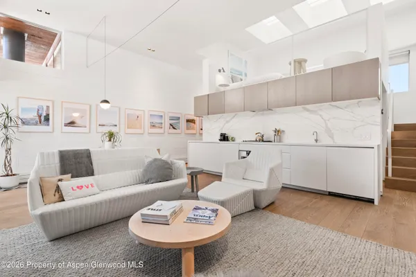 a living room with furniture and a kitchen view