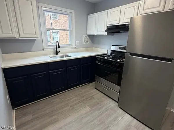 a kitchen with stainless steel appliances a refrigerator sink and cabinets