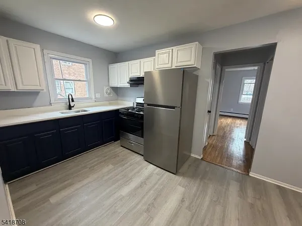 a kitchen with wooden cabinets sink and refrigerator