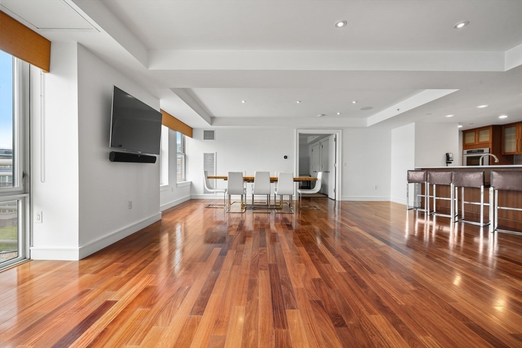 2 Battery Wharf, Unit 2504 Boston, MA 02109 - Photo 8 of 22 a living room with stainless steel appliances furniture wooden floor and a kitchen view