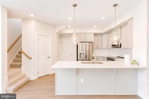 a large kitchen with kitchen island granite countertop a sink a counter top space and cabinets