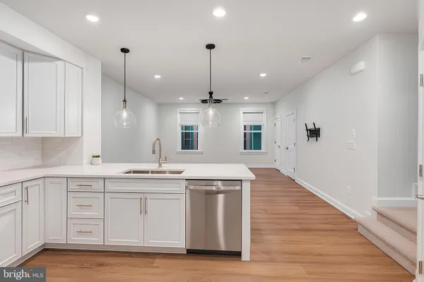 a large kitchen with granite countertop a large kitchen island a sink stainless steel appliances and cabinets